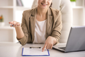 Businesswoman hand holding resume on desk.